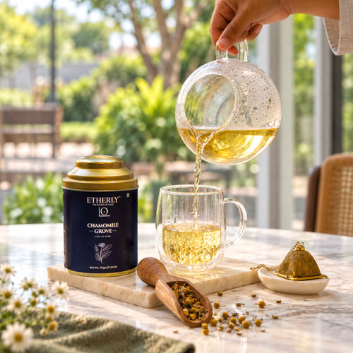 Chamomile tea poured from a glass teapot beside the Ease of Mind tea tin