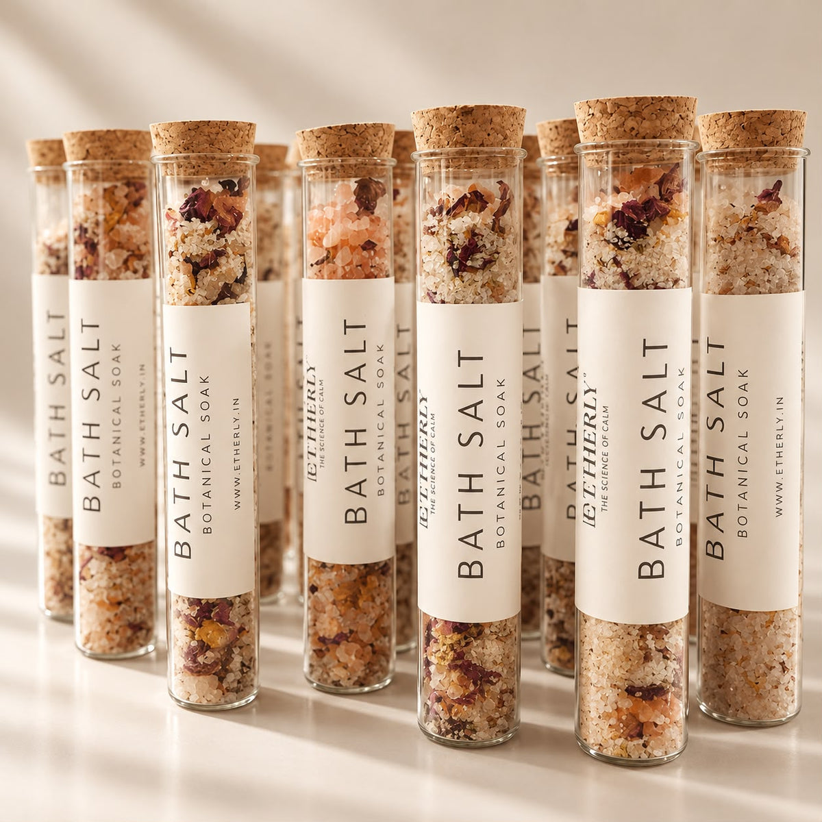Rows of Etherly bath salt tubes with dried rose petals and cork stoppers